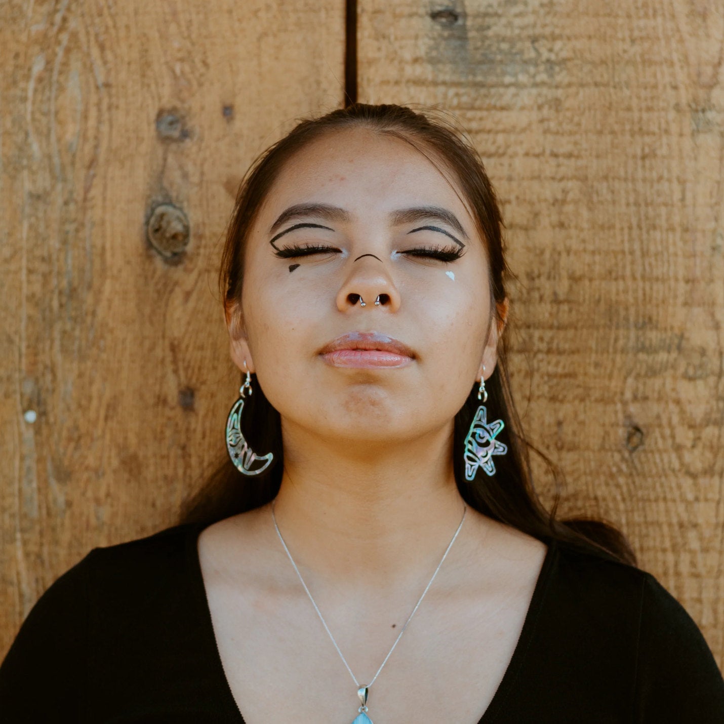 A youth model wears the "Hupal" sun and moon earrings from Copper Canoe Woman.