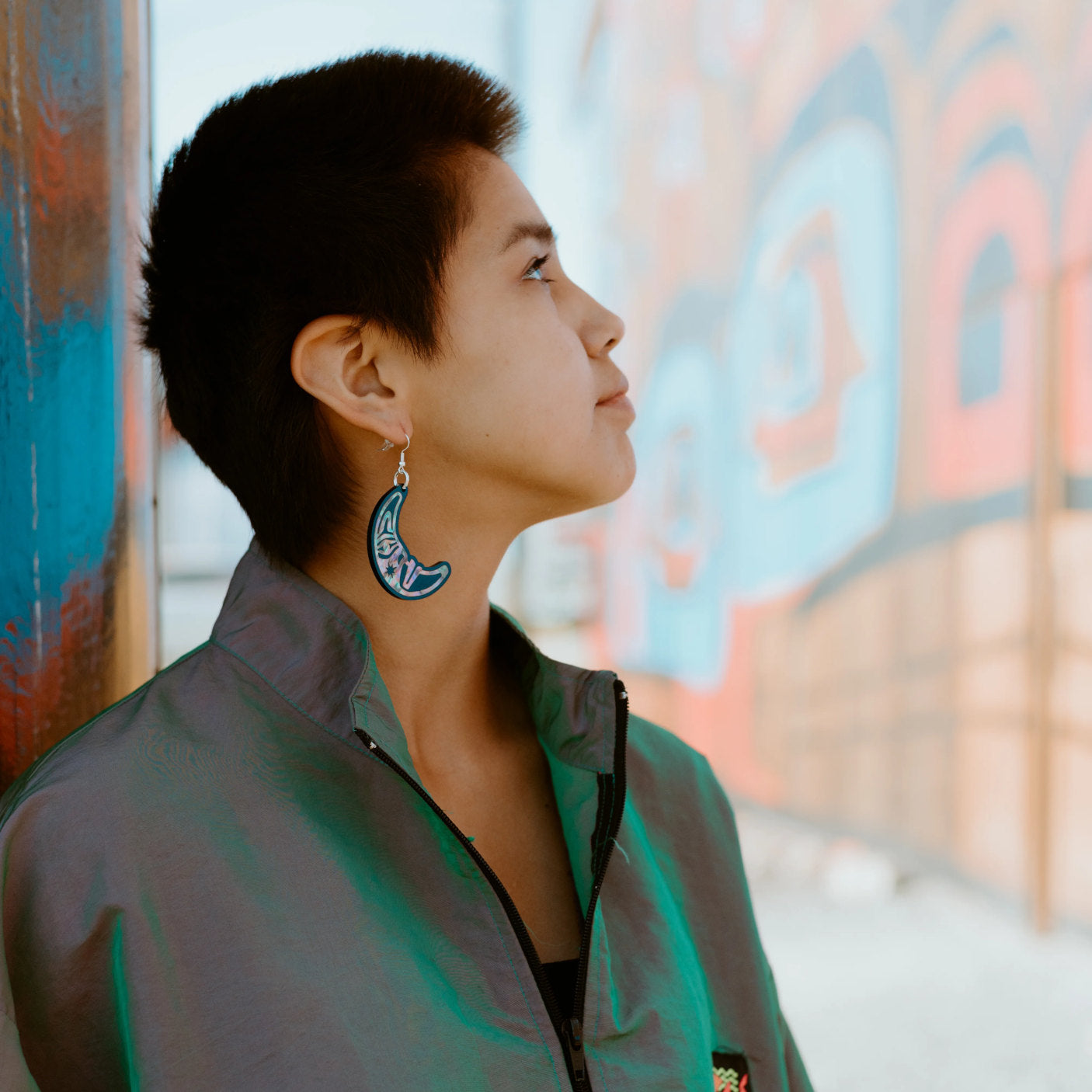 A model in profile shows the moon side of the "Hupal" earring from Copper Canoe Woman