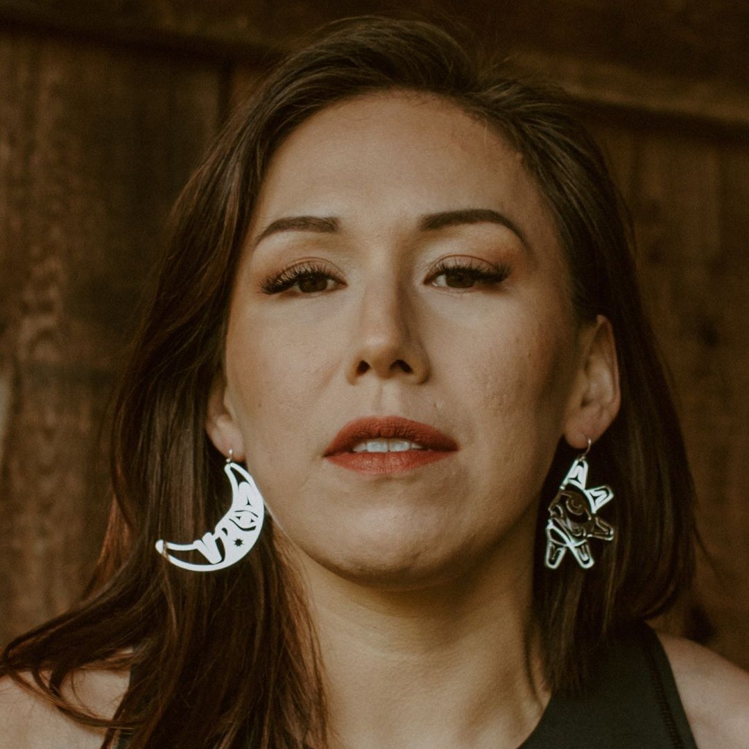 woman wearing sterling silver sun and moon with formline art cut outs from copper canoe woman