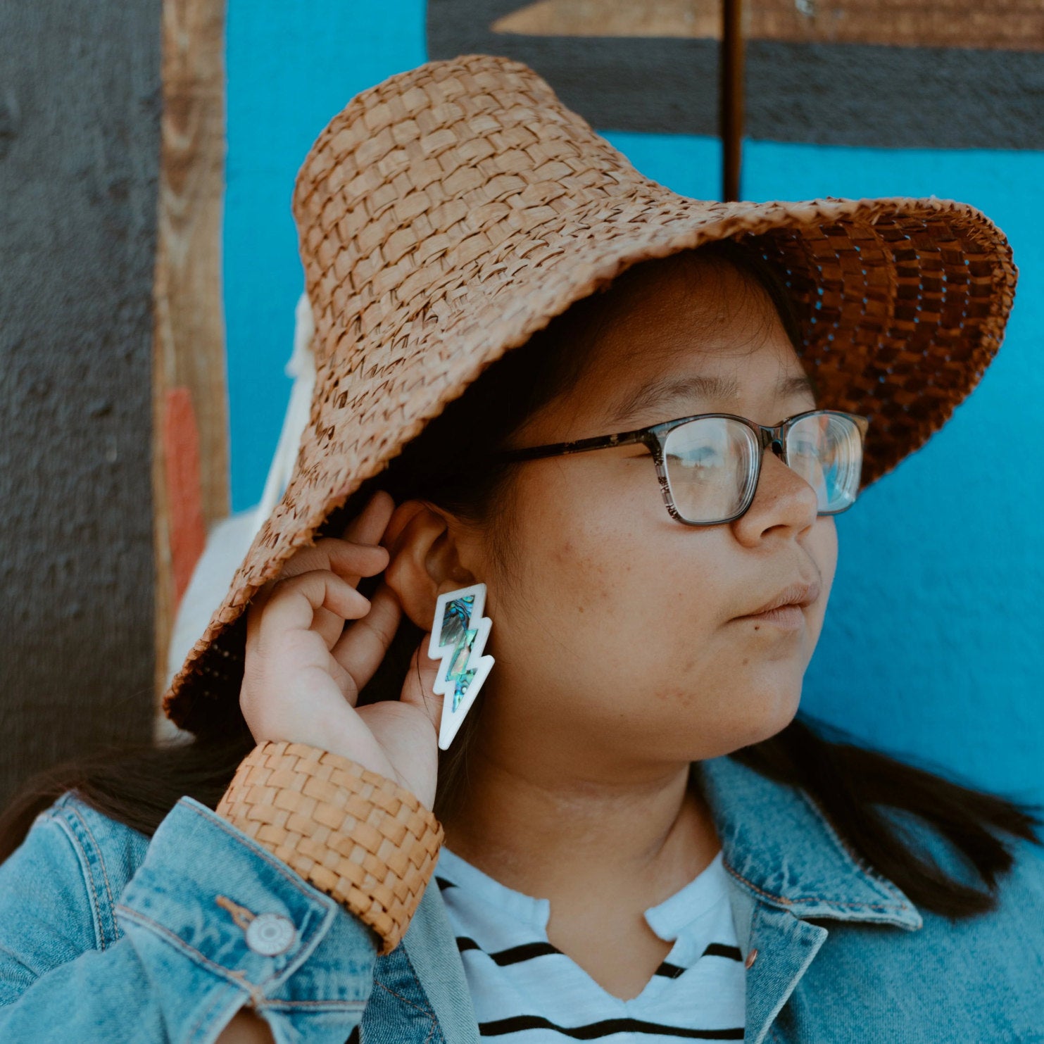 Young girl wearing white lightning bolt earring with abalone shell inlay from Copper Canoe Woman