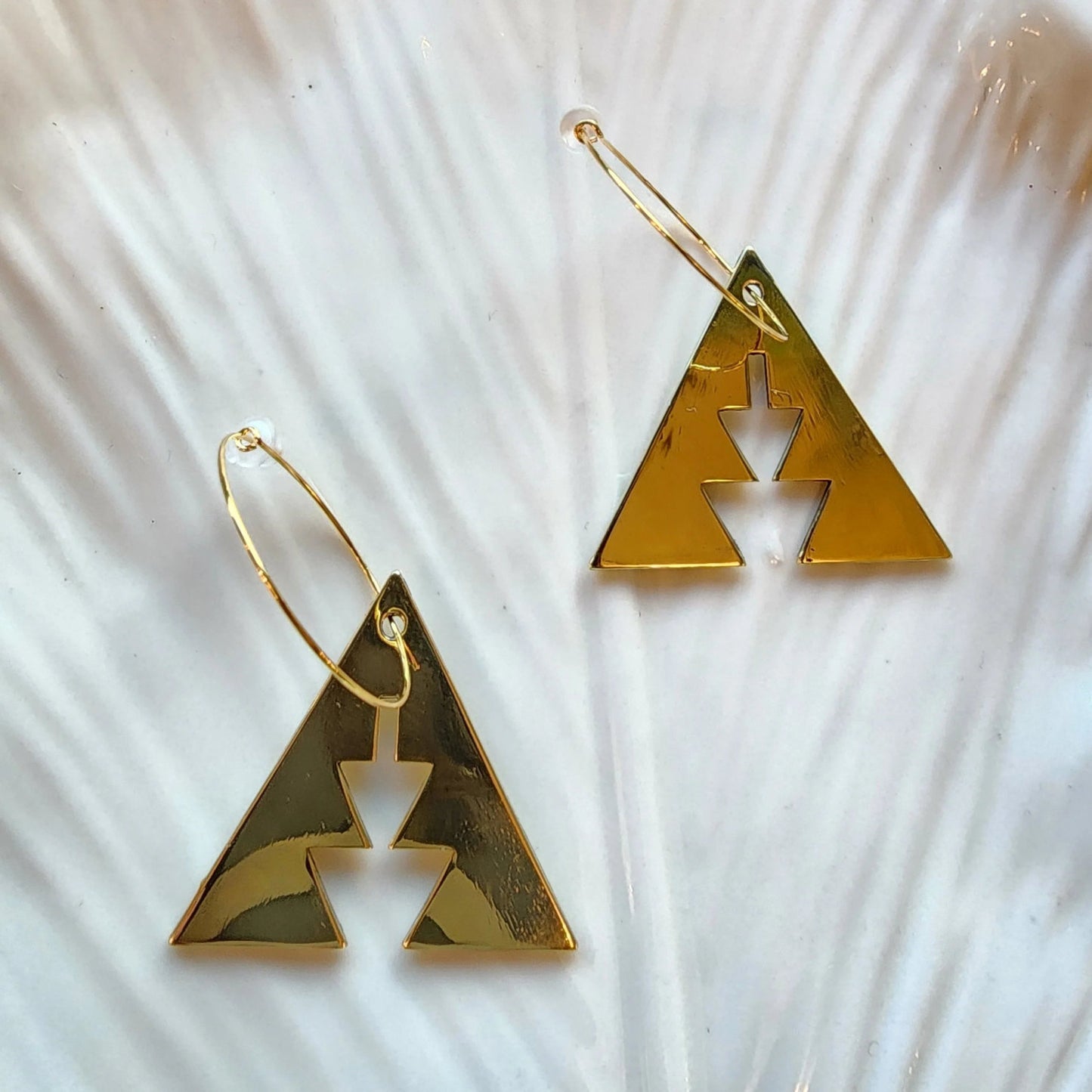 Brass triangle earrings with southwest geometric shapes from Copper Canoe Woman in a ceramic bowl.