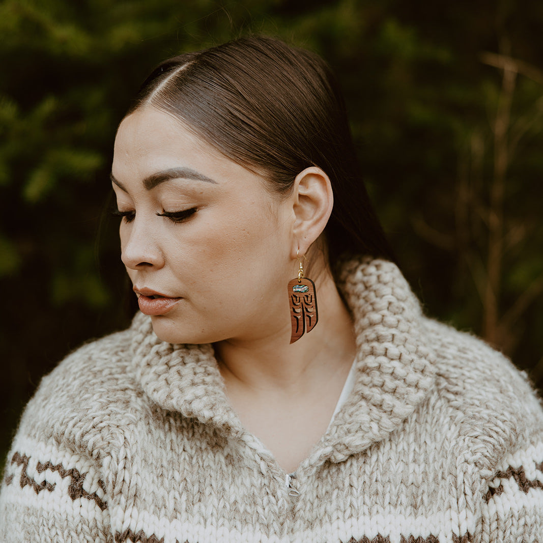 A model wears Copper Canoe Woman "Love Birds" earrings in cedar wood.