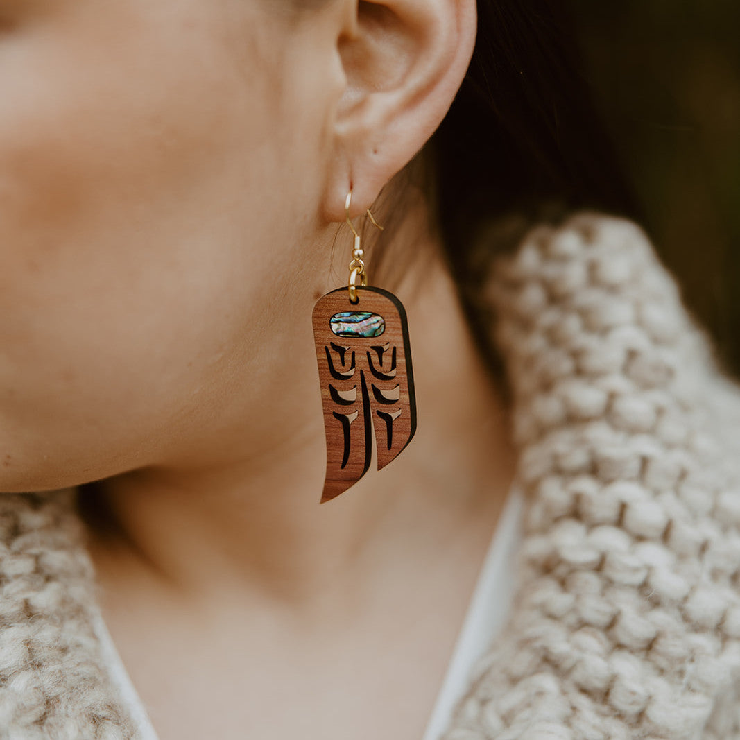 Closeup of cedar wood "Love Birds" earrings from Copper Canoe Woman