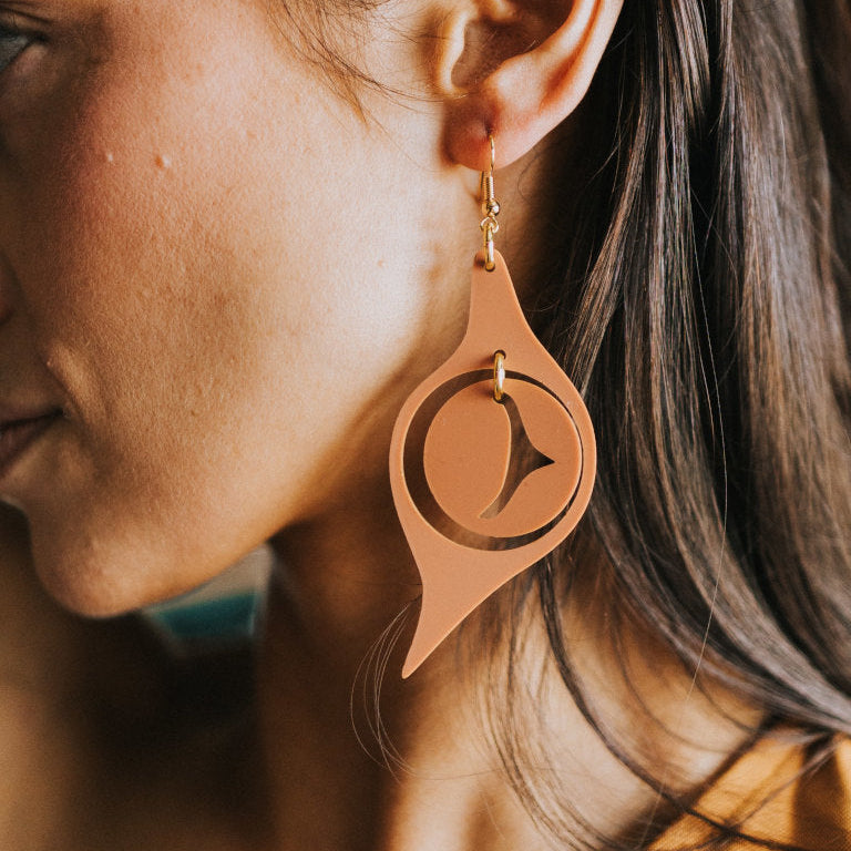 A closeup of an "Octopus Eye" earring from Copper Canoe Woman in terracotta acrylic.