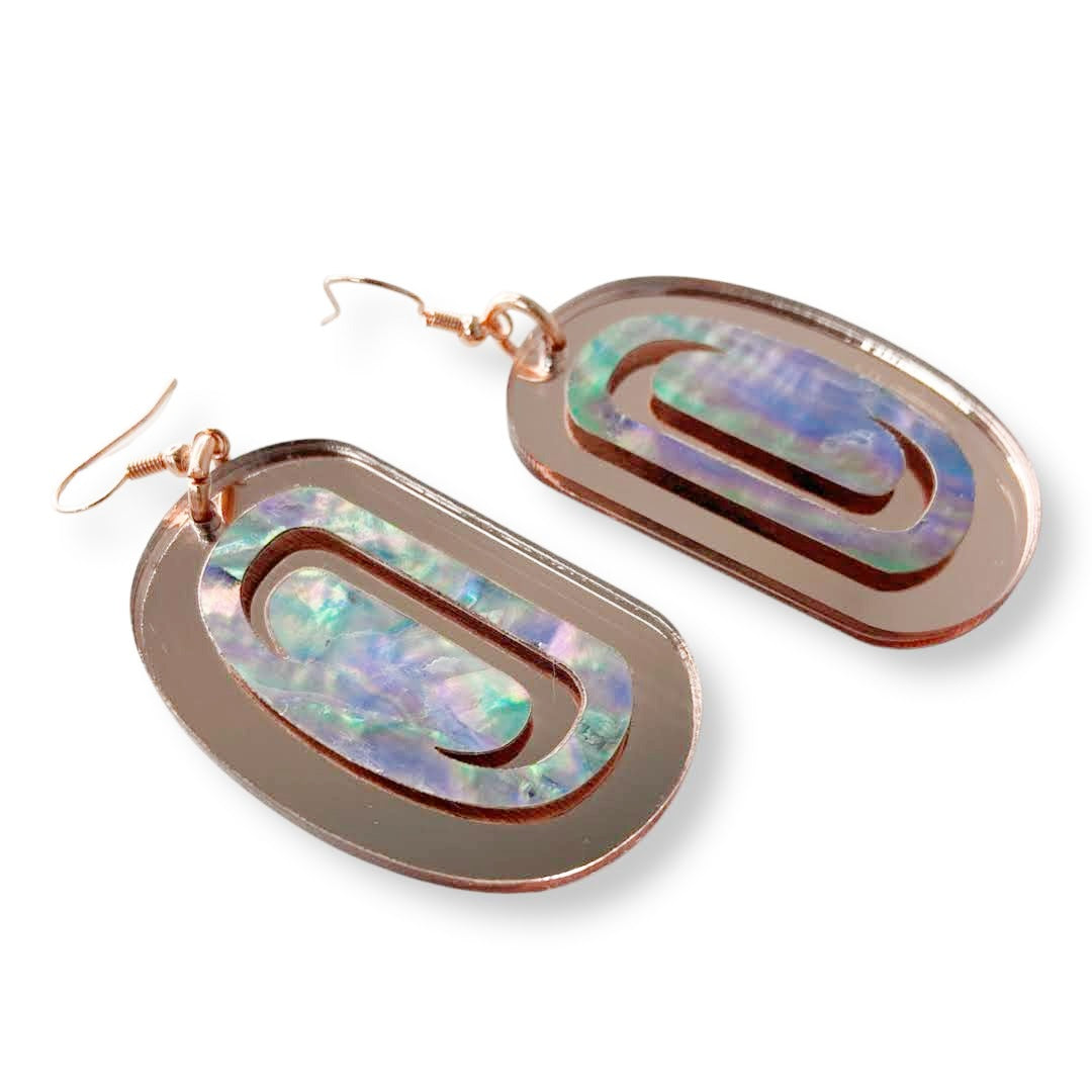 A pair of "Abalone Ovoid" earrings in rose gold mirror acrylic from Copper Canoe Woman.