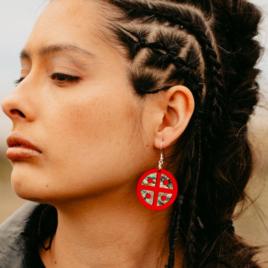 Profile of a model wearing the red mirror acrylic "Protector Shield" earring from Copper Canoe Woman.