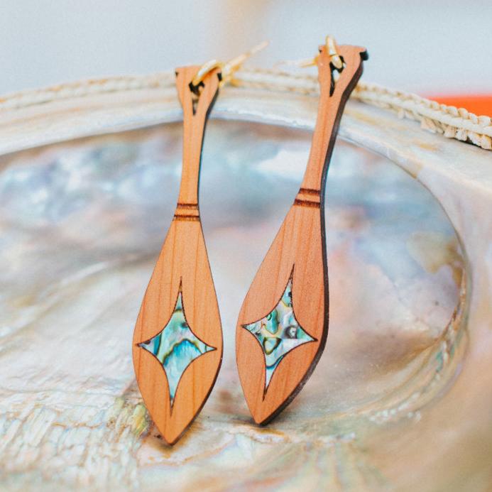cedar paddle earring with star abalone inlay from copper canoe woman