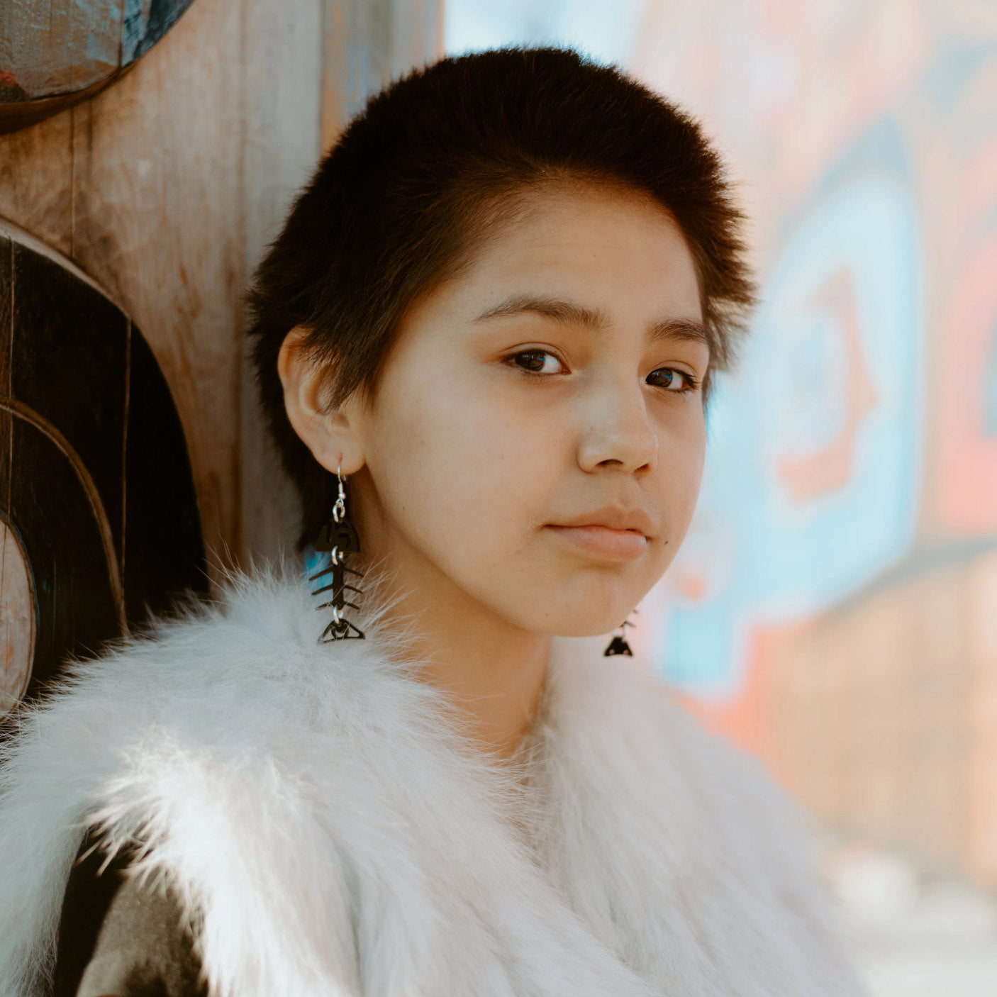 A model wearing the black acrylic small salmon ghost earring from Copper Canoe Woman.