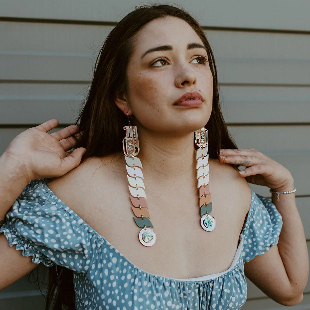 Model shows off a pair of pastel acrylic serpent earrings from Copper Canoe Woman.