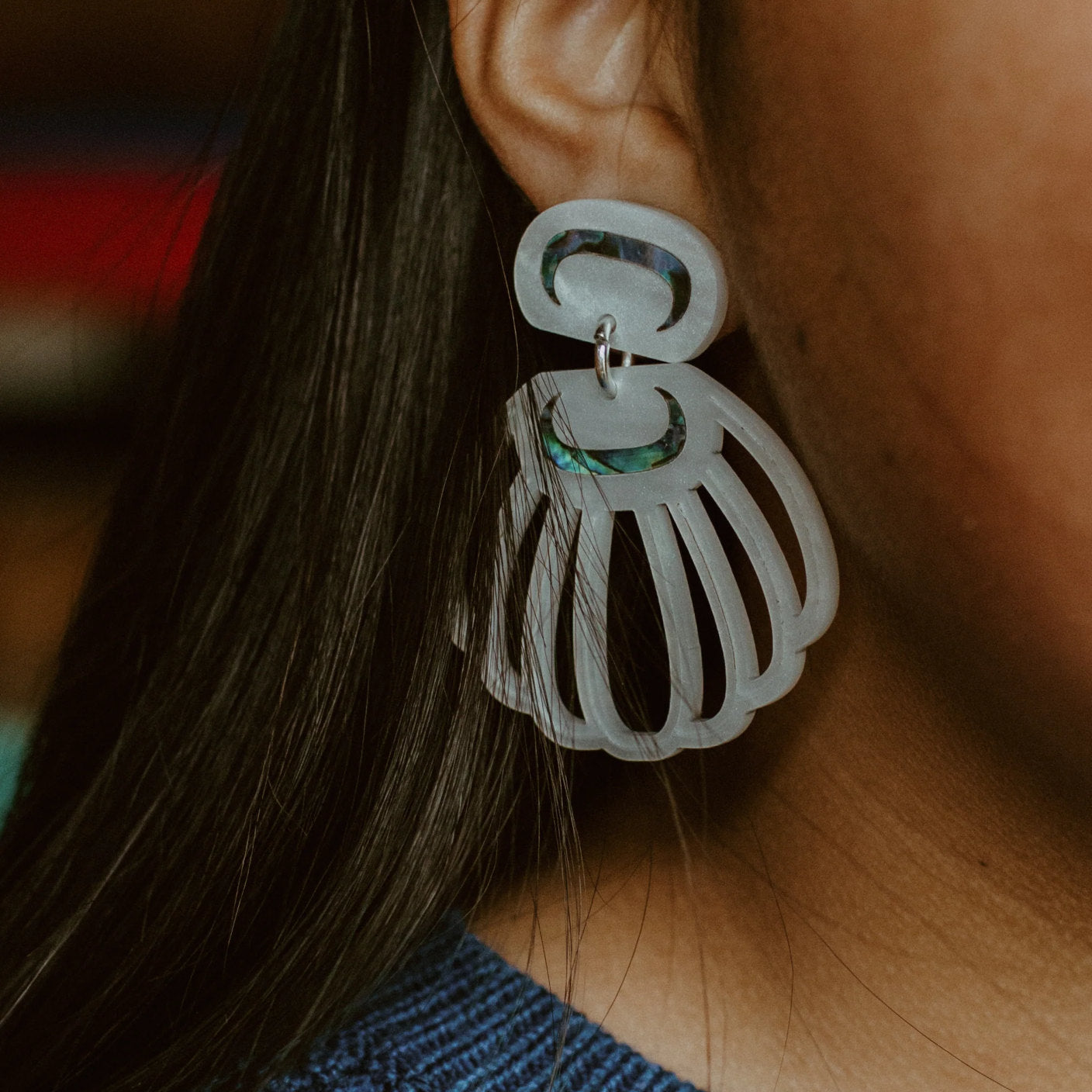 Close up of a model wearing pearl acrylic "Shell Woman" earrings from Copper Canoe Woman.