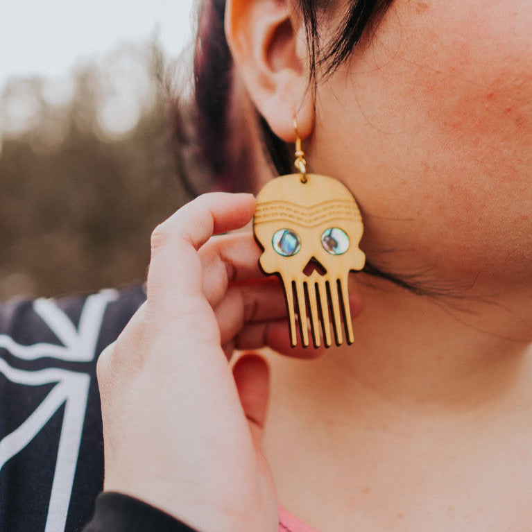 A closeup of the cedar "Skull Comb" earring from Copper Canoe Woman.