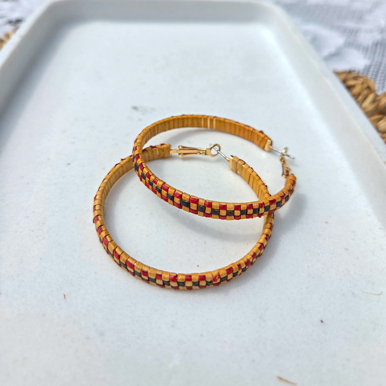 Pair of colorful beaded hoop earrings on a white surface