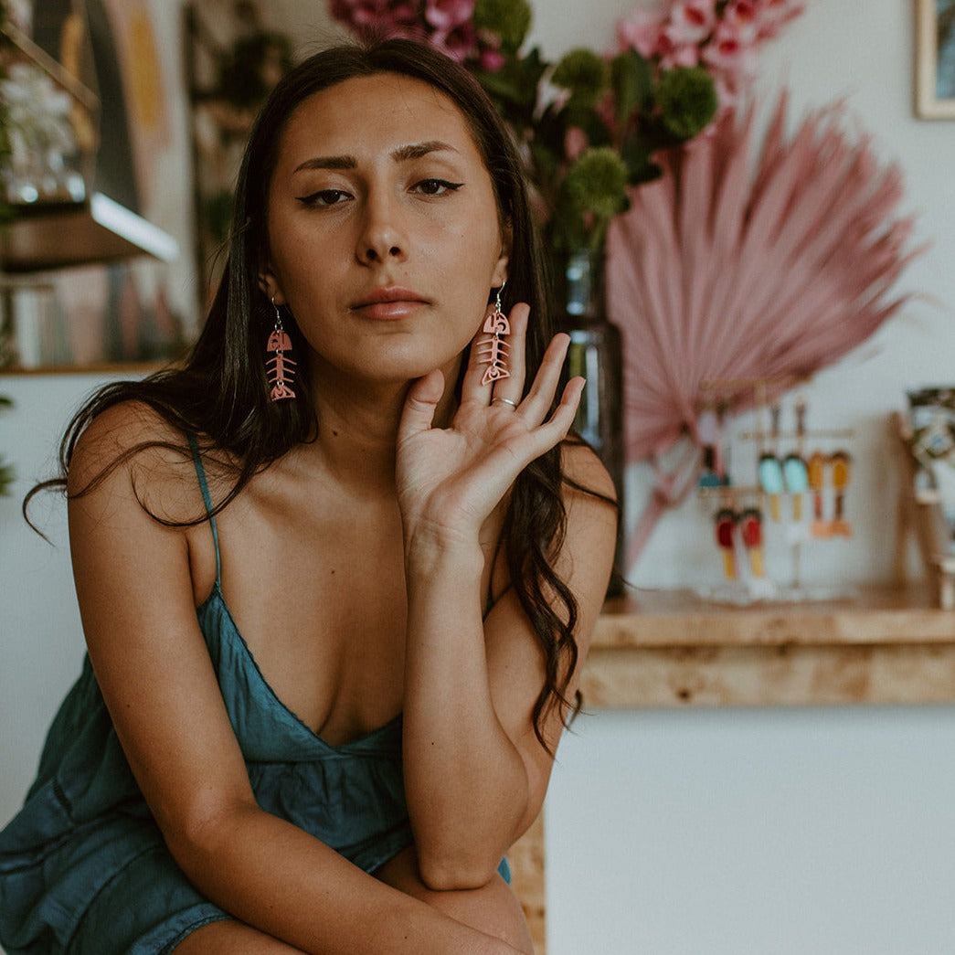 Model wears matte coral small salmon ghost earrings