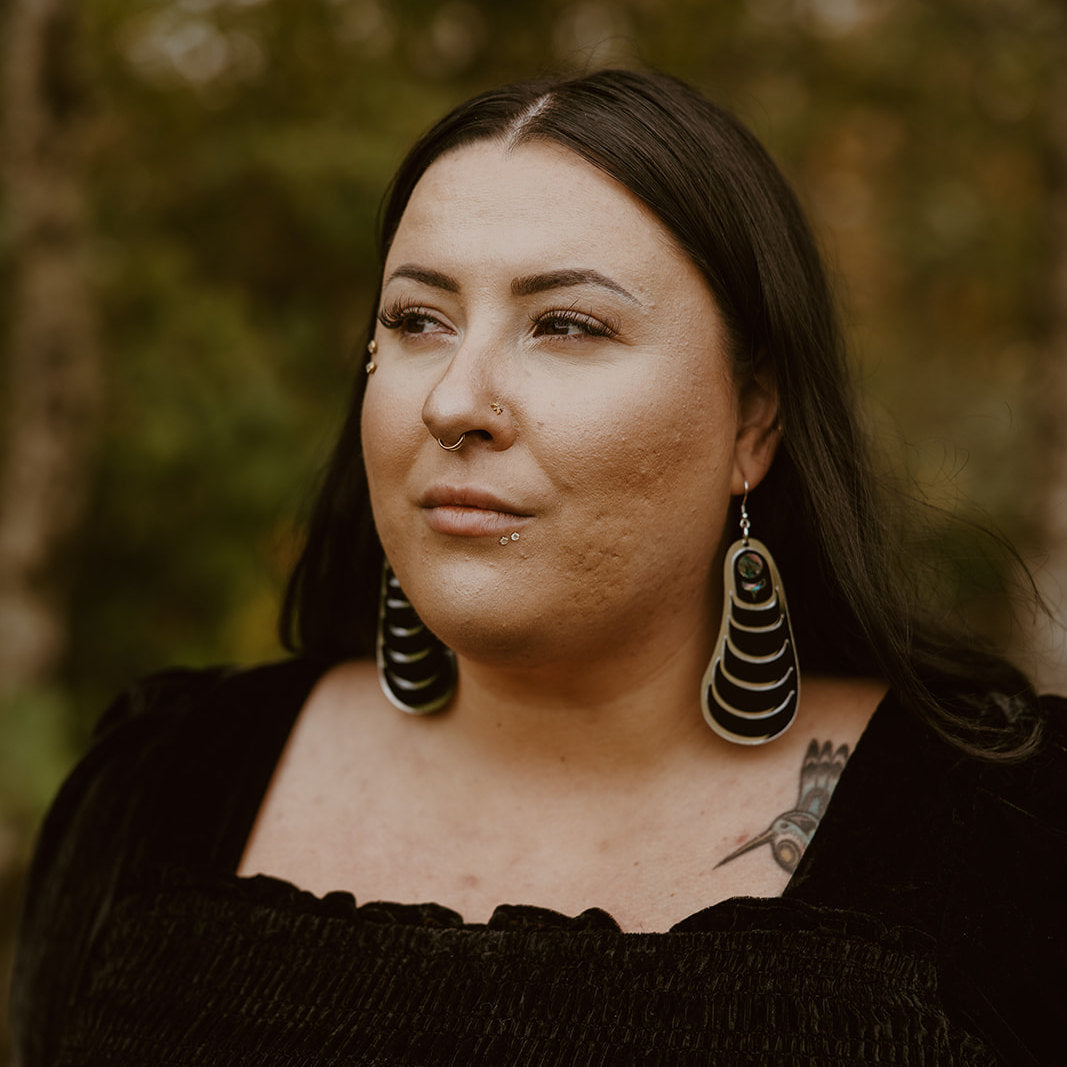 Model wearing the black acrylic version of the "Coastal Strata" earring by Copper Canoe Woman.