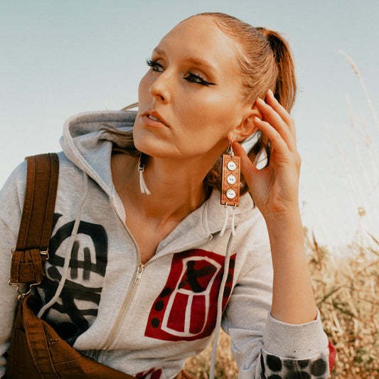 A model wearing a pair of cedar wood "Echoes of Celebration" earrings from Copper Canoe Woman.