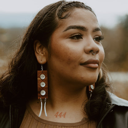 A model wearing a pair of "Echoes of Celebration" earrings from Copper Canoe Woman.
