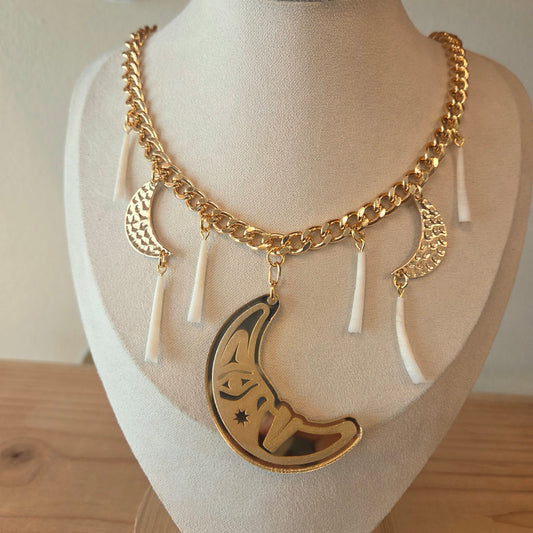 Gold necklace with crescent moon pendant and dentalium on a mannequin bust from Copper Canoe Woman.
