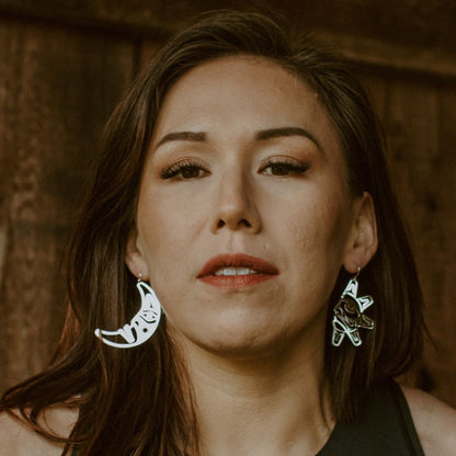 woman wearing sterling silver sun and moon with formline art cut outs from copper canoe woman