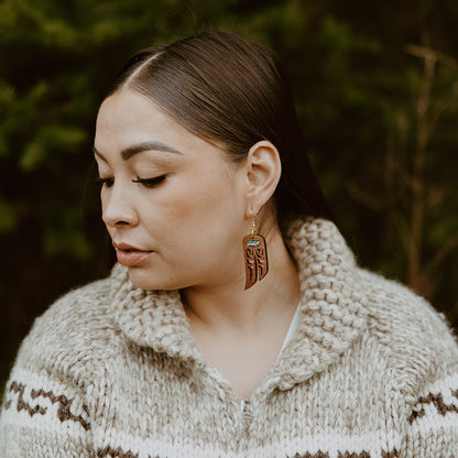 A model wears Copper Canoe Woman "Love Birds" earrings in cedar wood.