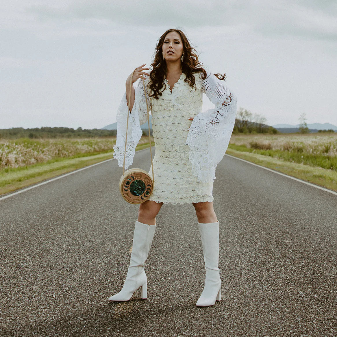 Woman in white dress holding READY TO SHIP purse on road