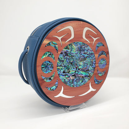 Blue faux leather circular handbag with cedar wood nala design in abalone and gold inlay from Copper Canoe Woman.