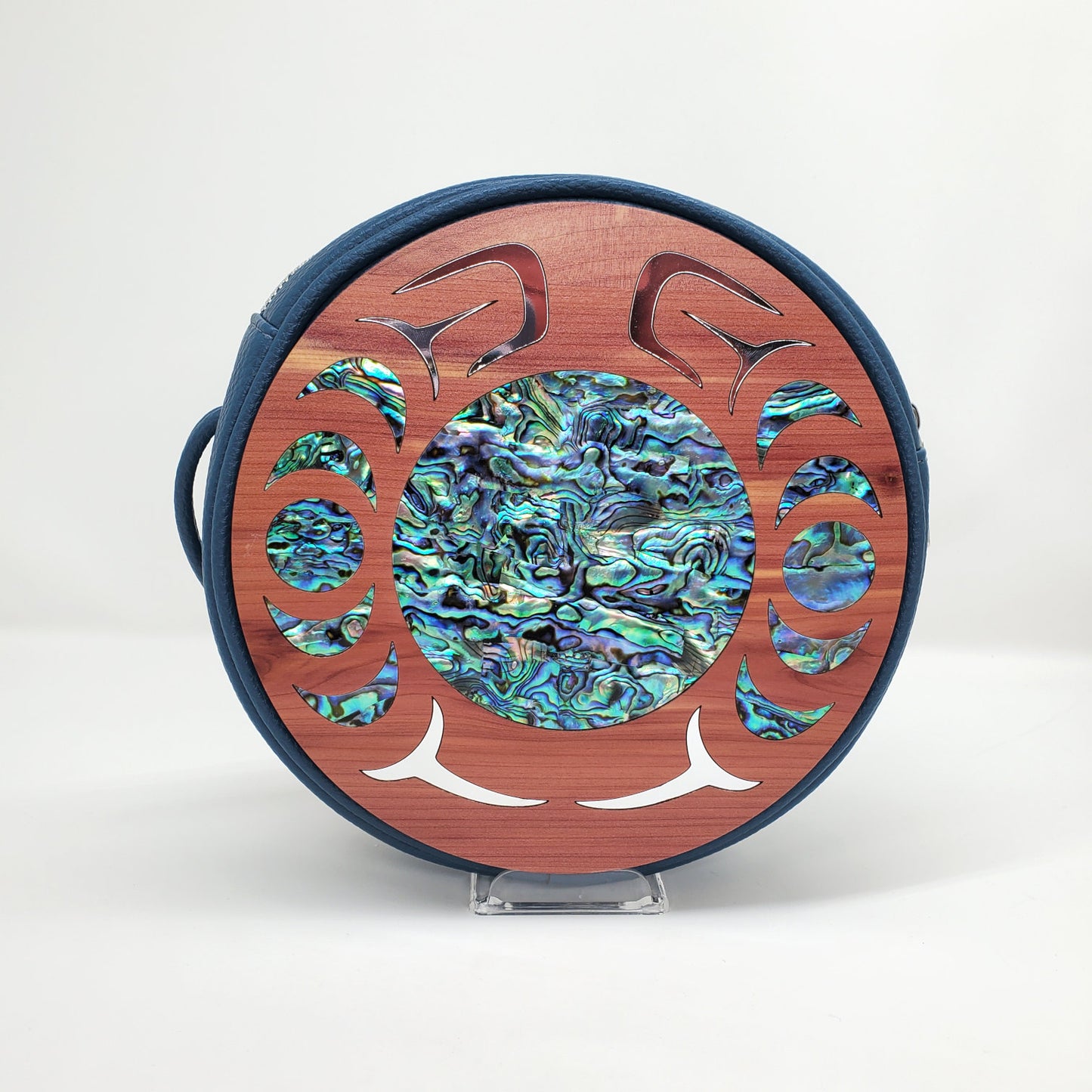 Blue faux leather handbag with circular cedar wood nala design from Copper Canoe Woman and abalone and gold inlay .