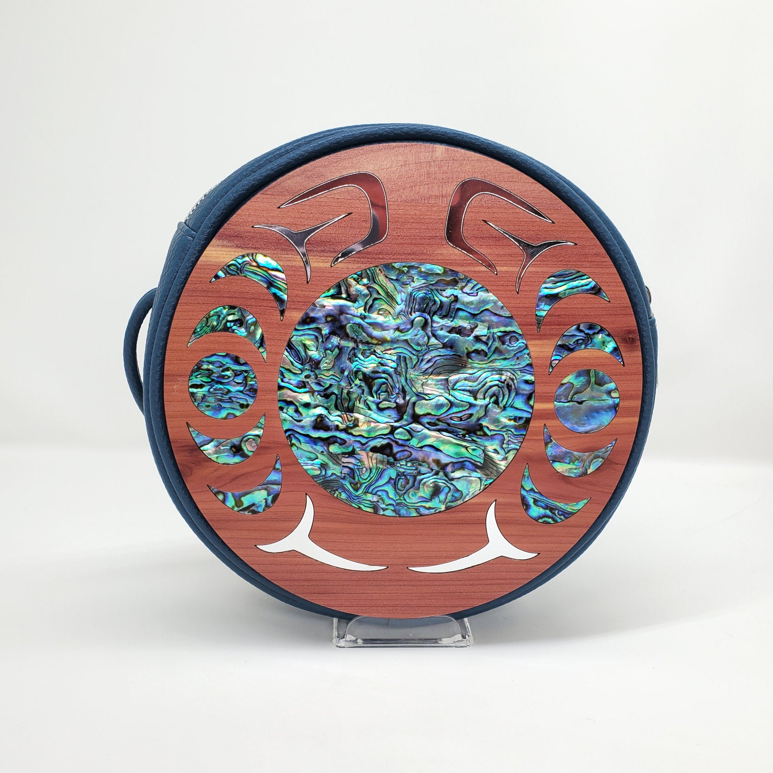 Blue faux leather handbag with circular cedar wood nala design from Copper Canoe Woman and abalone and gold inlay .