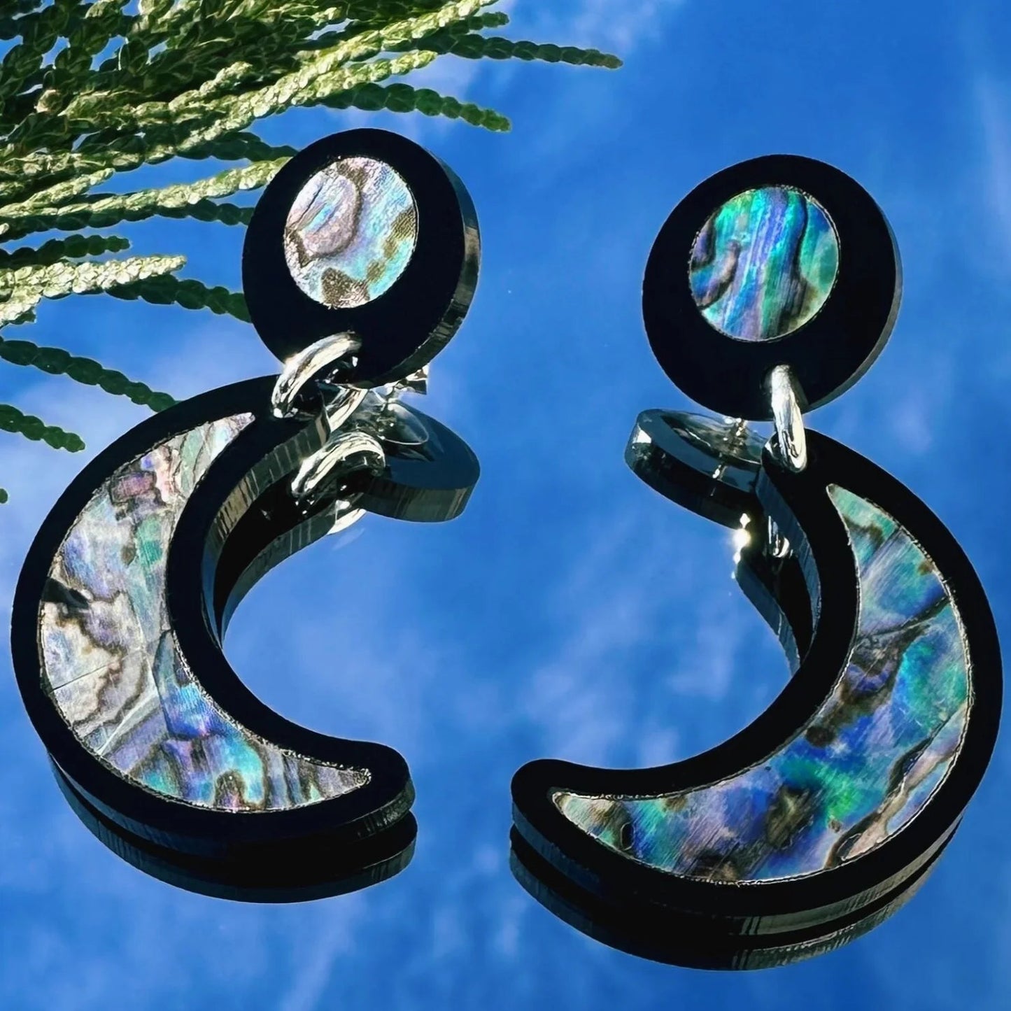 A pair of "Nuci" crescent moon post earrings in black acrylic from Copper Canoe Woman.