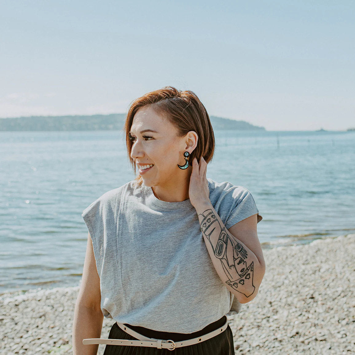 Black acrylic "Nuci" crescent moon earrings from Copper Canoe Woman worn by a model.