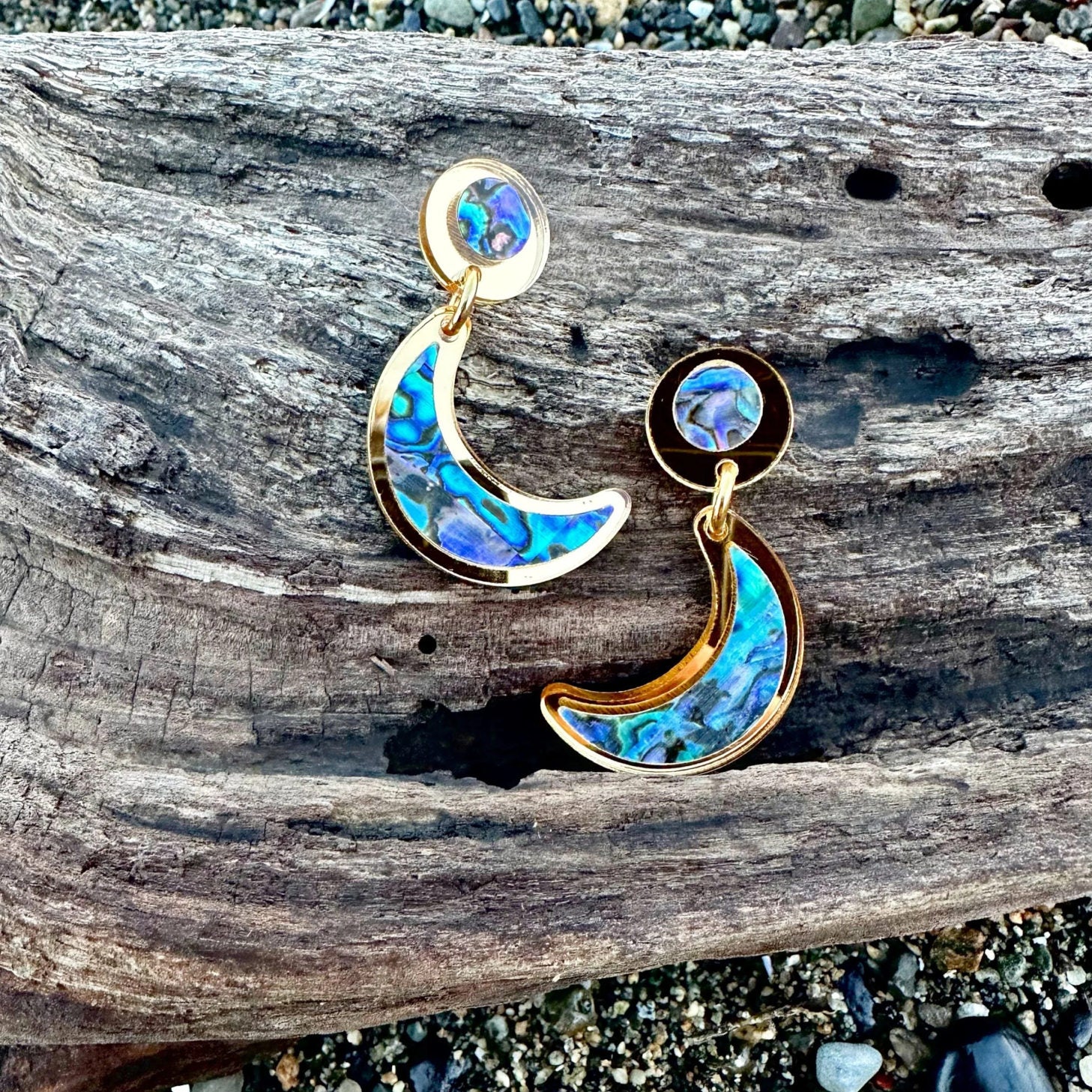 A pair of post "Nuci" crescent moon earrings in gold mirror acrylic from Copper Canoe Woman.