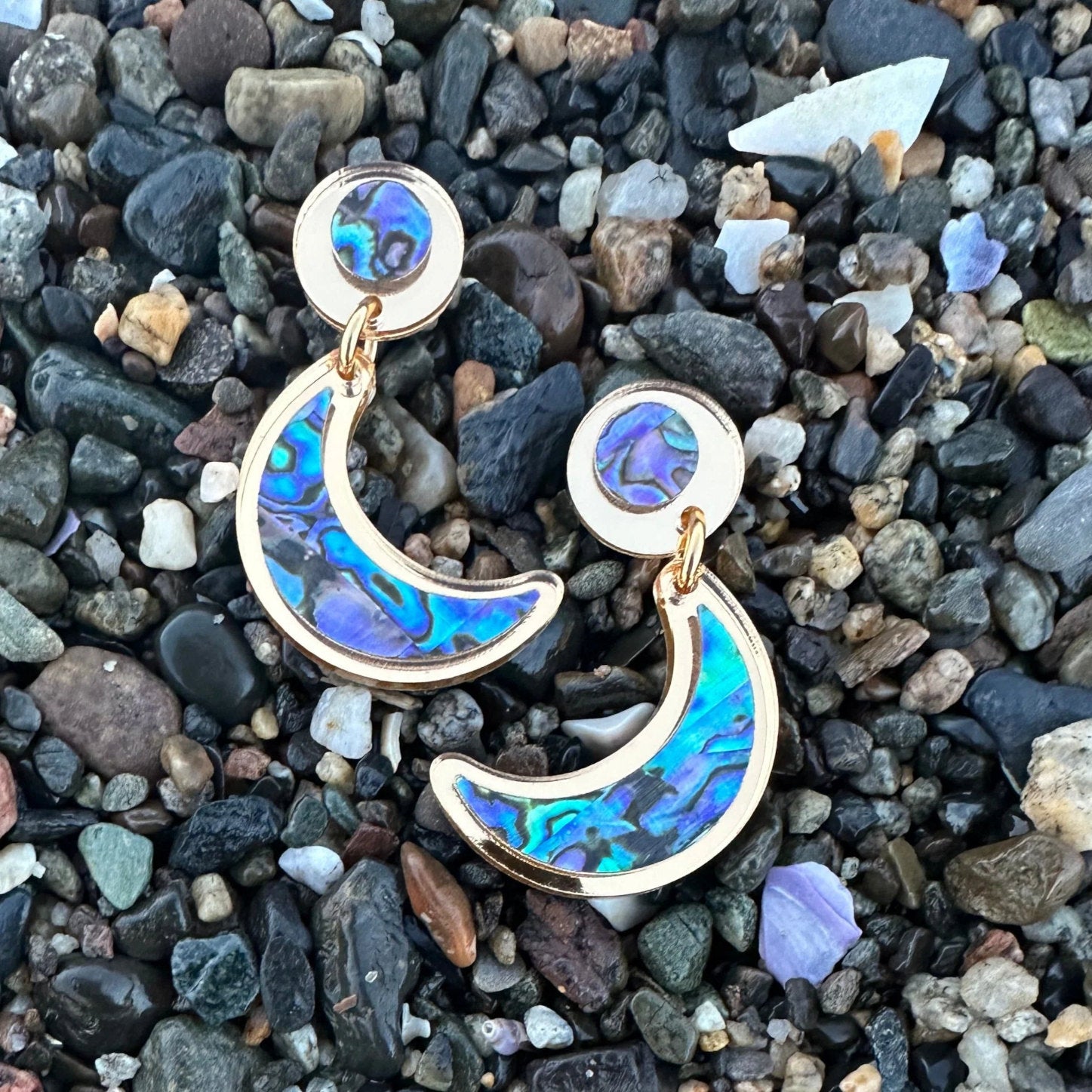 A pair of post version "Nuci" crescent moon post earrings in gold mirror acrylic from Copper Canoe Woman.