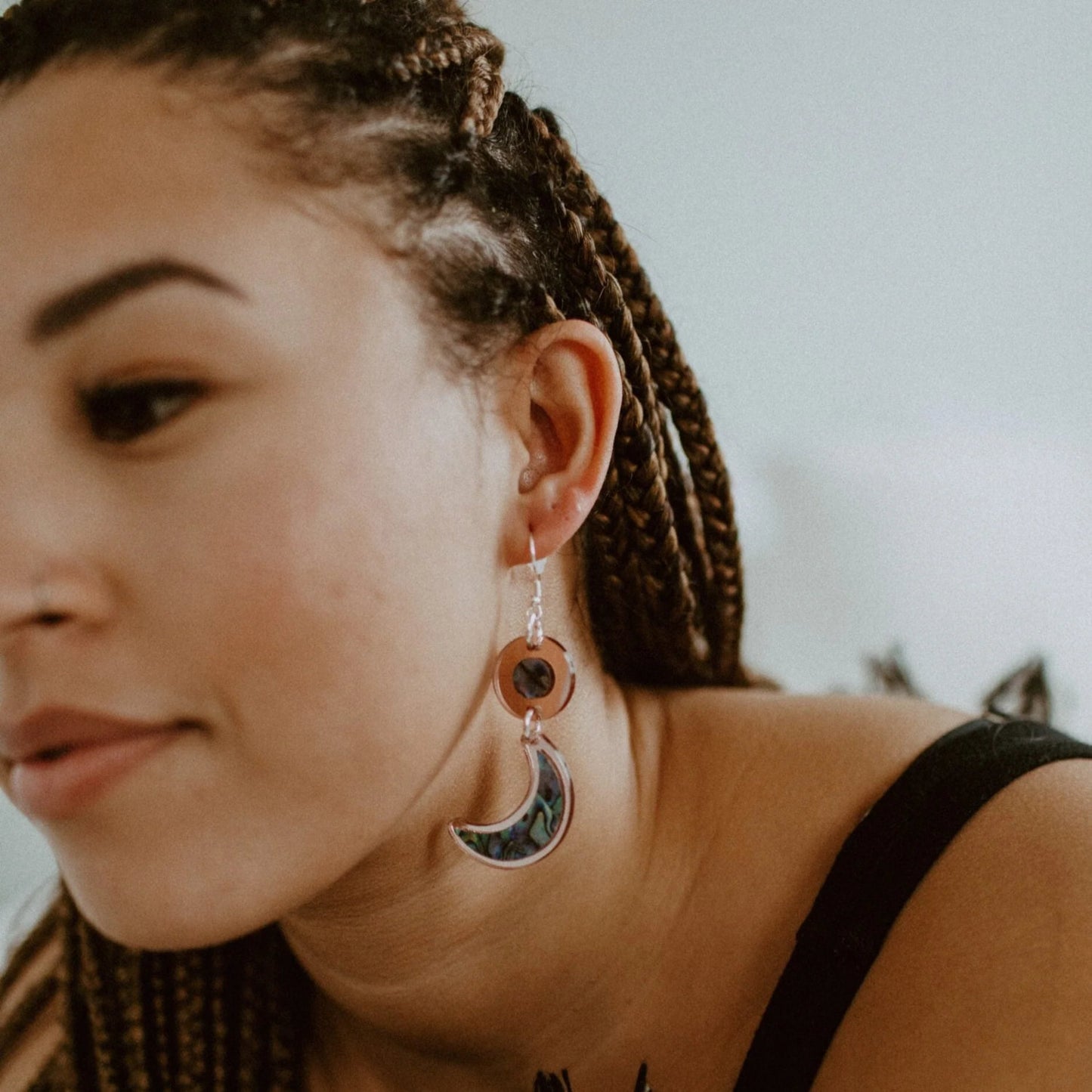 A model wearing rose gold mirror acrylic "Nuci" crescent moon earrings from Copper Canoe Woman.