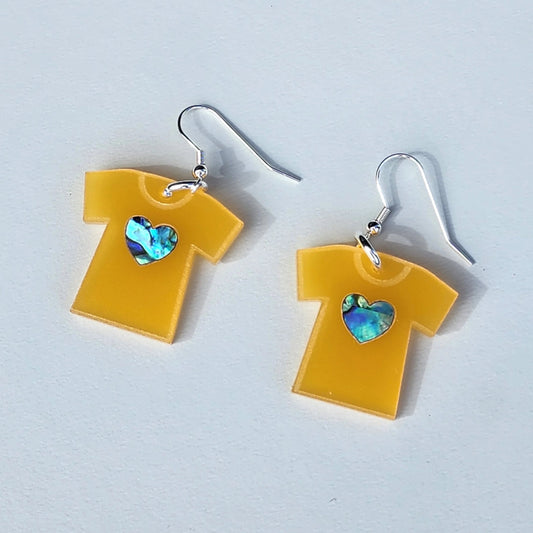 A pair of "Orange Shirt" acrylic earrings from Copper Canoe Woman lay on a white background.