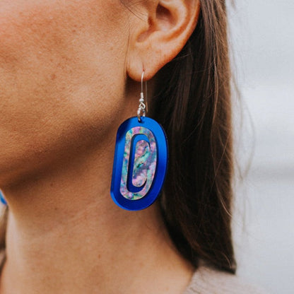 Closeup of a model wearing cobalt mirror "Abalone Ovoid" earrings from Copper Canoe Woman.