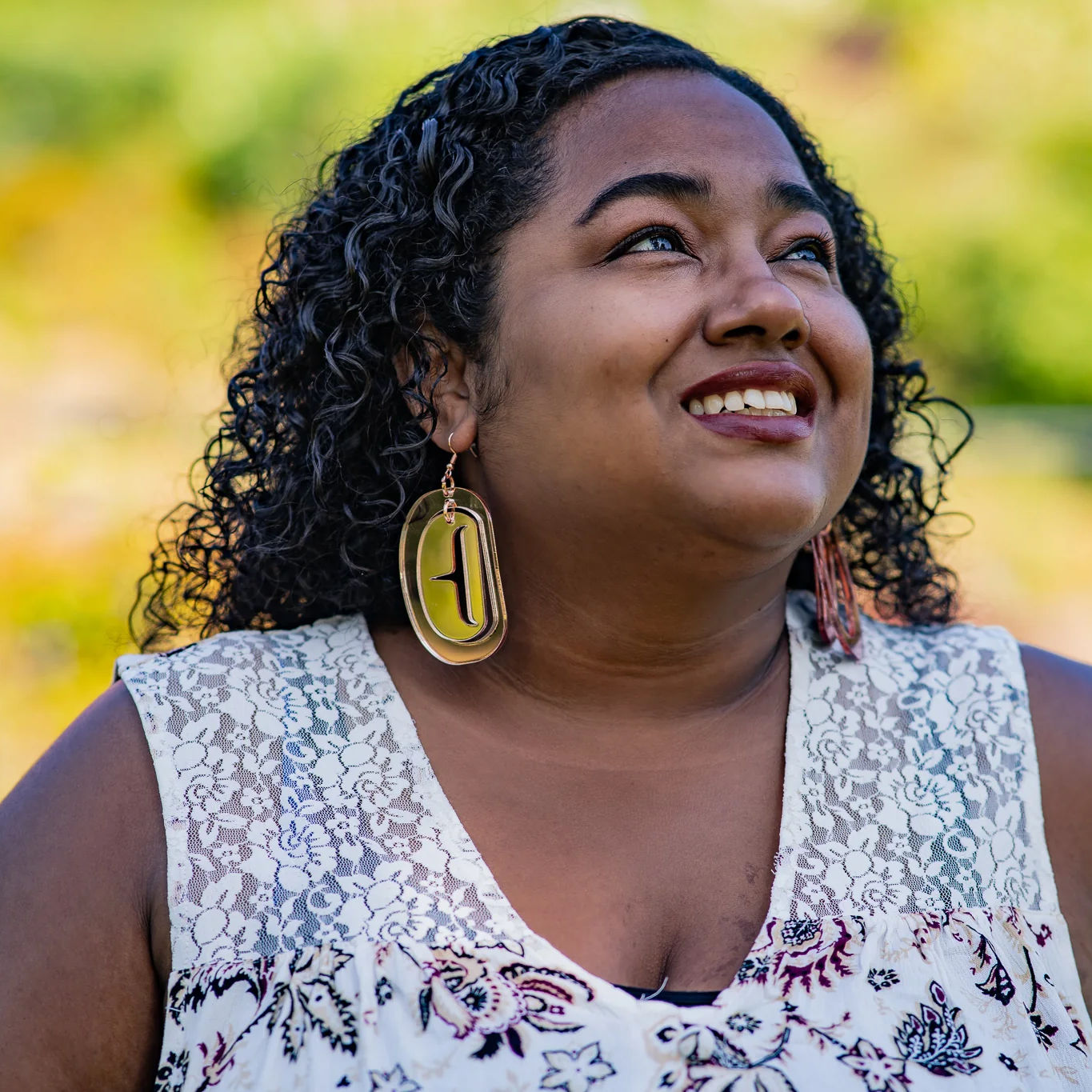 Copper Canoe Woman iridescent acrylic large ovoid earrings worn by a model looking toward the sky