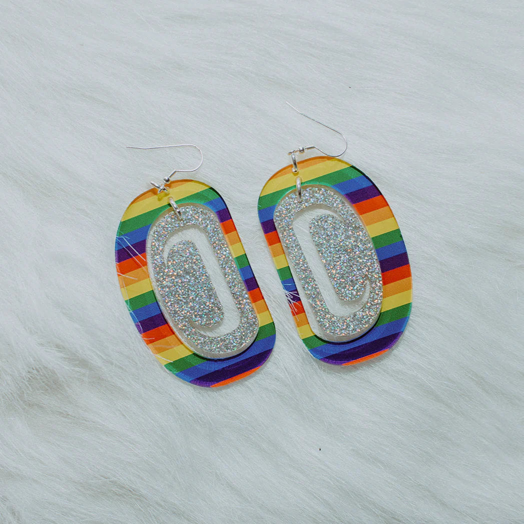 A pair of large ovoid earrings in rainbow and holographic glitter acrylic from Copper Canoe Woman.