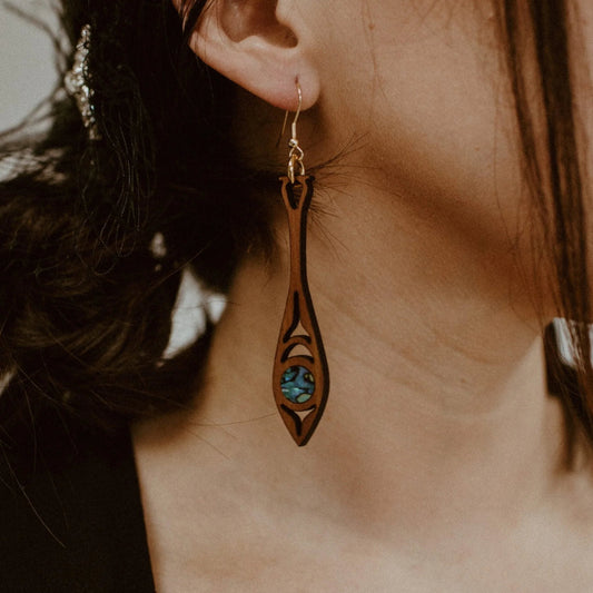 Close up of a model wearing the cedar wood "Paddle Song" earring from Copper Canoe Woman.