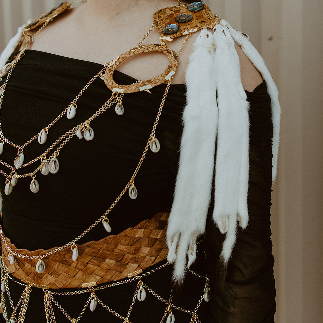 Person wearing a decorative gold and black outfit with white feathers