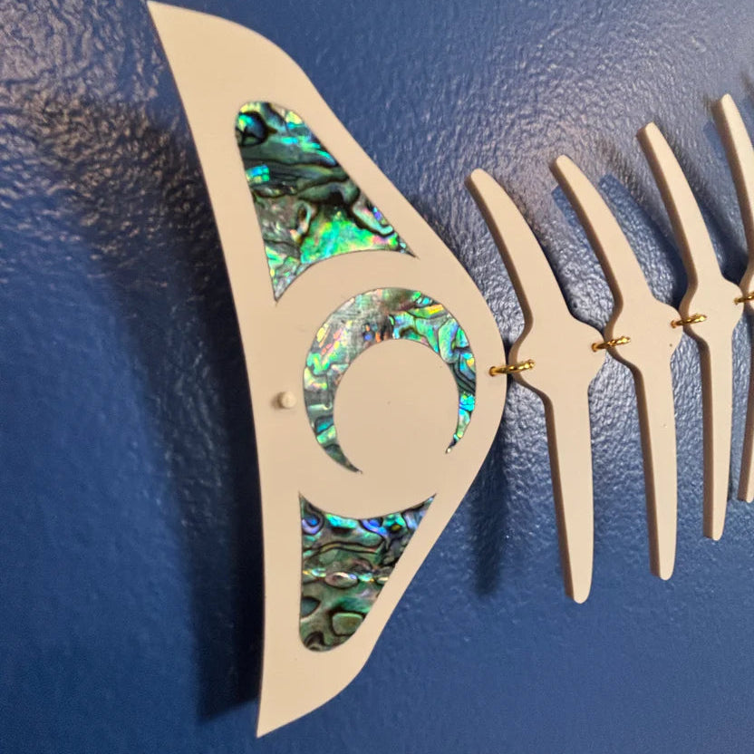 close up of tail of ivory copper canoe woman salmon ghost design wall art on a blue background