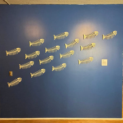 Blue wall with ivory copper canoe woman salmon ghost design wall art. 