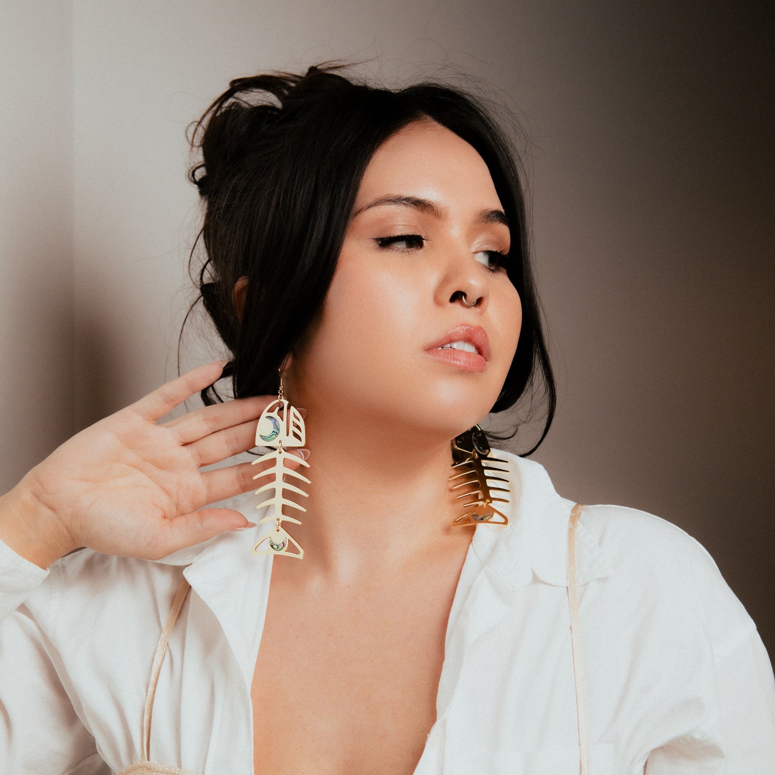 Elegant Women Model wearing medium 14k gold salmon ghost earrings with abalone accents.
