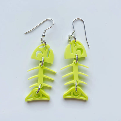 A pair of neon pear acrylic small salmon ghost earrings from Copper Canoe Woman laying on a white background.
