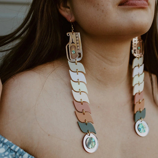 Closeup of model wearing the pastel acrylic serpent earrings from Copper Canoe Woman.
