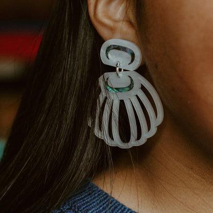Close up of a model wearing pearl acrylic "Shell Woman" earrings from Copper Canoe Woman.