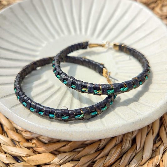Two black beaded bracelets with green accents on a white plate.