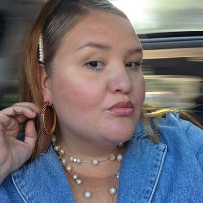 women wearing Pair of woven hoop earrings with red and black checkered pattern.