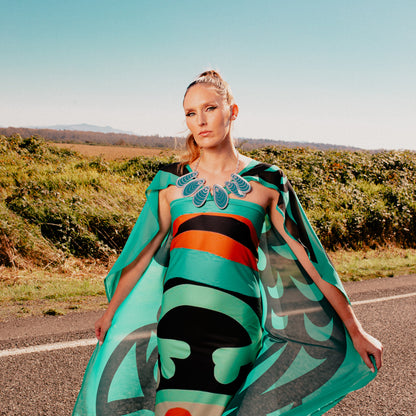A model stands on a road wearing the "Tidal Reflections" necklace by Copper Canoe Woman.