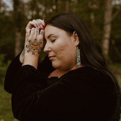 woman wearing silver mirror long rectangle warrior spirit earring with triangle zig zag abalone inlay from copper canoe woman